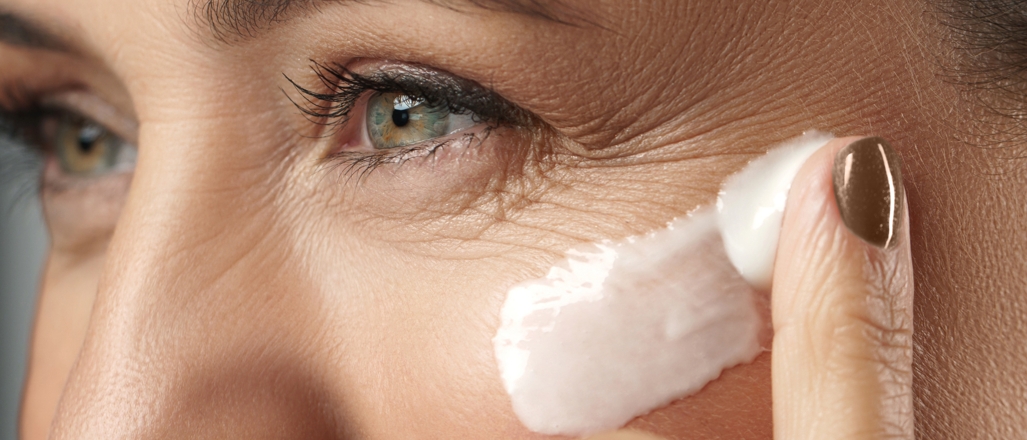 Žena si maže krém na obličej.